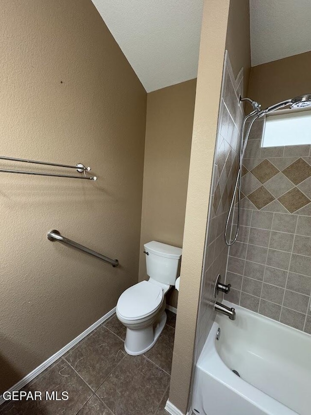 bathroom featuring a textured ceiling, tile patterned flooring, toilet, tiled shower / bath, and lofted ceiling