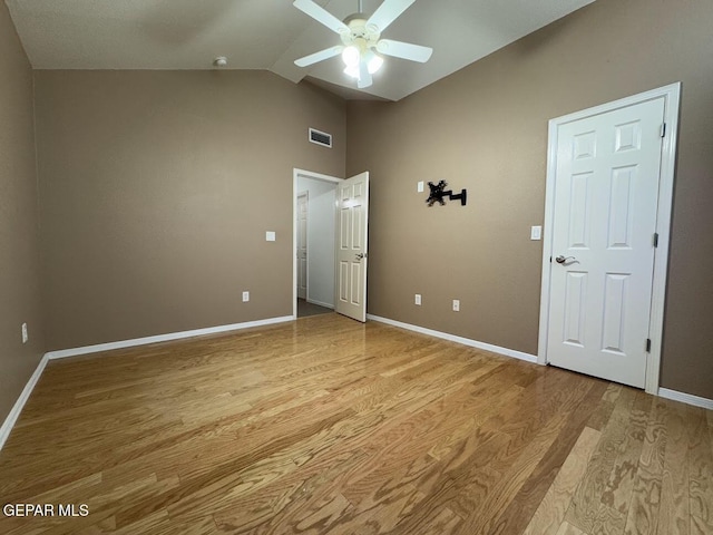 unfurnished bedroom with ceiling fan, vaulted ceiling, and light wood-type flooring