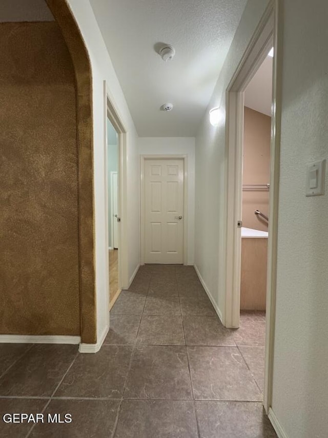 hall with tile patterned floors