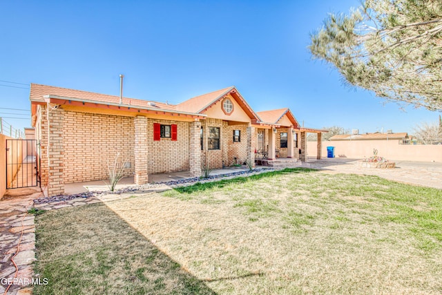 back of house featuring a lawn and a patio