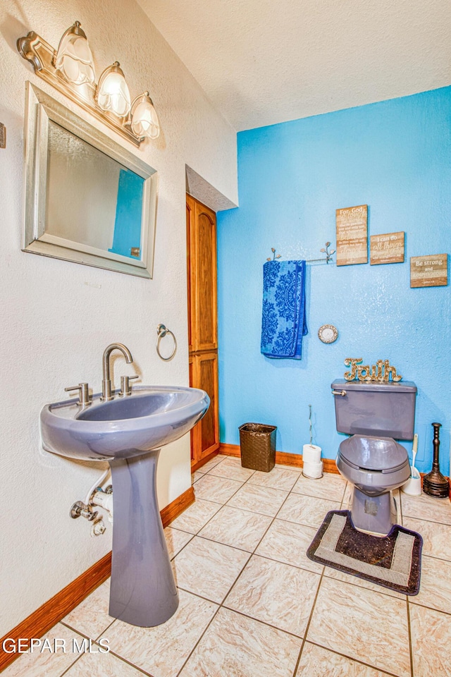 bathroom with a textured ceiling and tile patterned floors