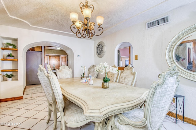 dining space with a chandelier, a textured ceiling, built in features, and light tile patterned flooring