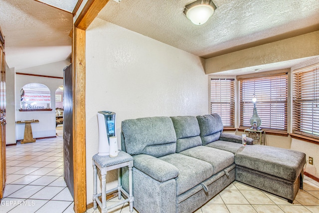 living room with a textured ceiling and light tile patterned flooring