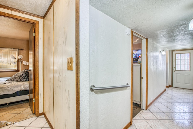 hallway featuring light tile patterned floors and a textured ceiling