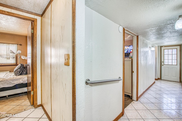 hall with light tile patterned flooring and a textured ceiling