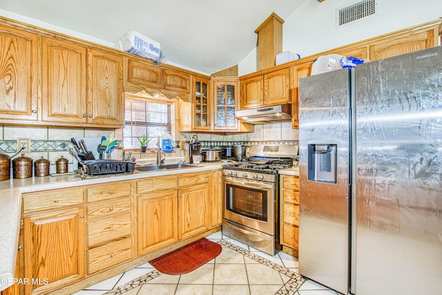 kitchen featuring decorative backsplash, black fridge with ice dispenser, gas range, sink, and light tile patterned flooring