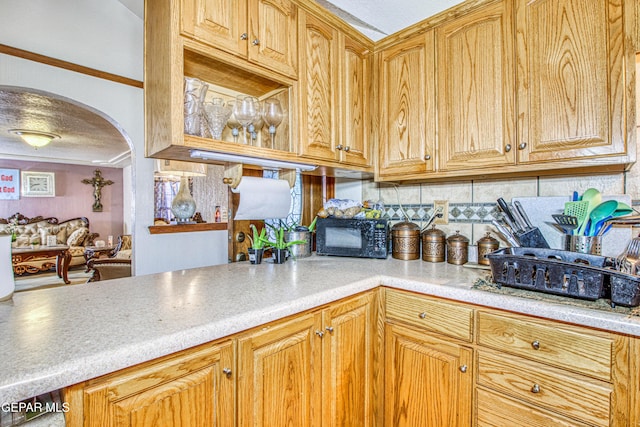 kitchen with decorative backsplash, ornamental molding, and a textured ceiling