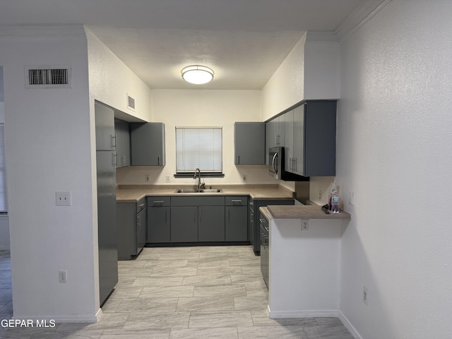 kitchen with kitchen peninsula, stainless steel appliances, gray cabinets, and sink