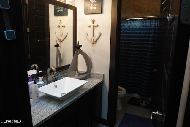 bathroom with vanity, tile patterned floors, toilet, and walk in shower