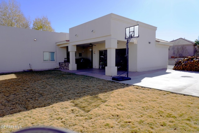 back of house featuring ceiling fan, a patio area, and a lawn