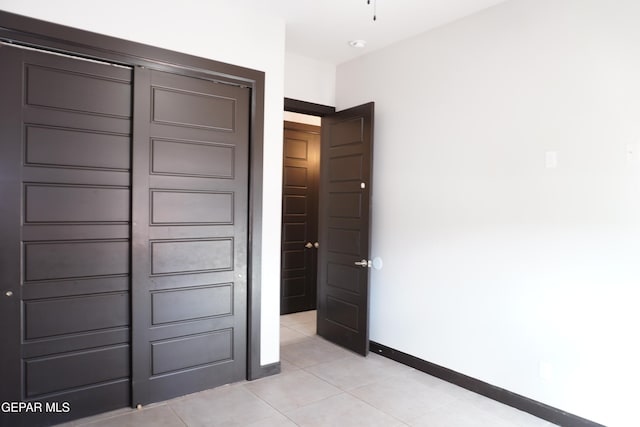 unfurnished bedroom featuring a closet and light tile patterned floors