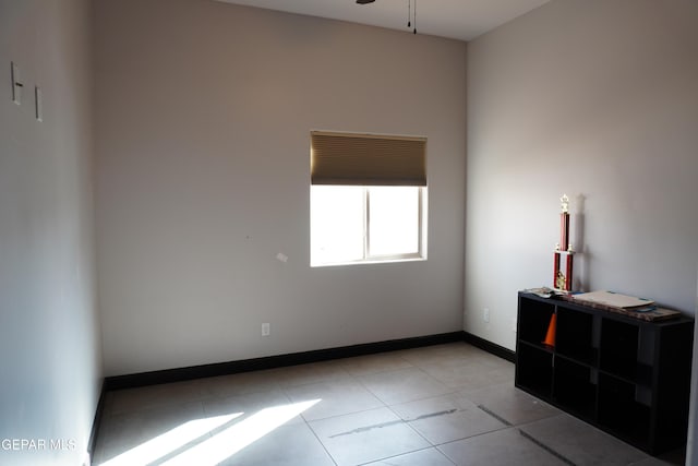 unfurnished room with ceiling fan and light tile patterned floors