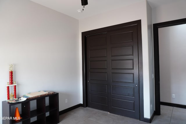 foyer entrance with light tile patterned floors and ceiling fan