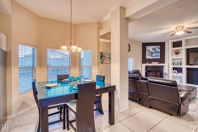 dining area with ceiling fan with notable chandelier, built in features, and light tile patterned flooring