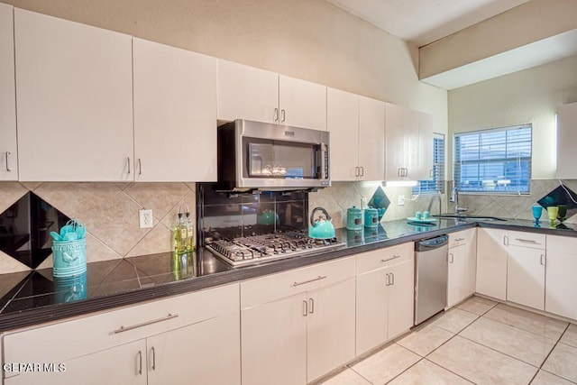 kitchen with white cabinets, light tile patterned floors, sink, and appliances with stainless steel finishes