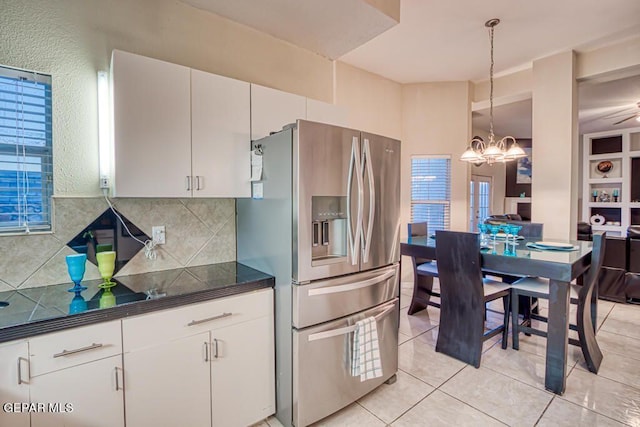 kitchen featuring decorative light fixtures, white cabinetry, stainless steel fridge with ice dispenser, and backsplash