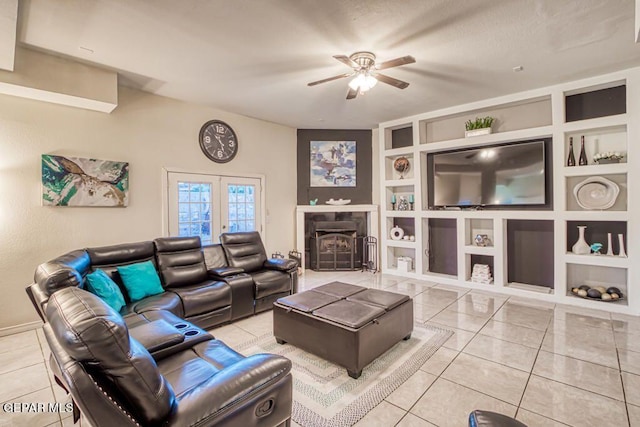 tiled living room with built in shelves, ceiling fan, french doors, and lofted ceiling