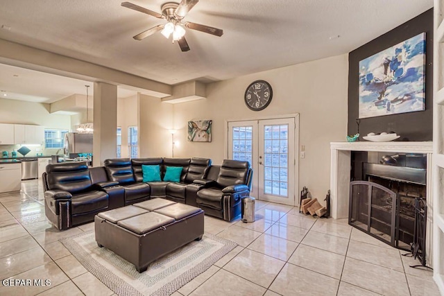 tiled living room with ceiling fan and french doors