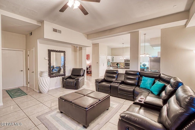 tiled living room with ceiling fan with notable chandelier