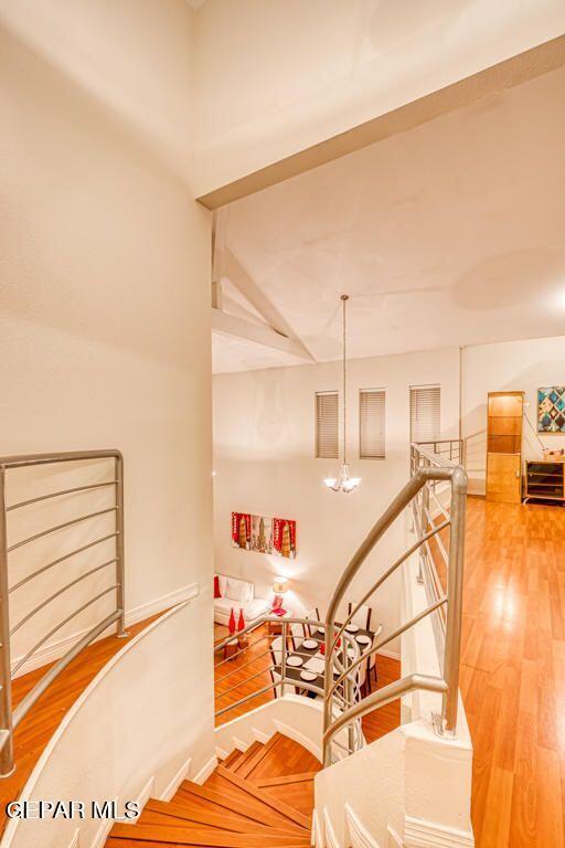 staircase with a chandelier and wood-type flooring