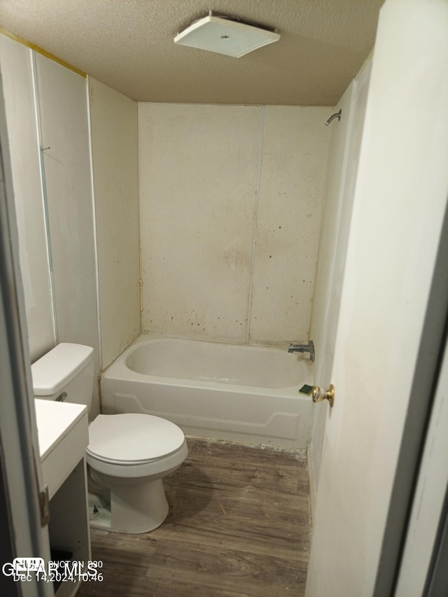 bathroom featuring vanity, hardwood / wood-style floors, a textured ceiling, and toilet