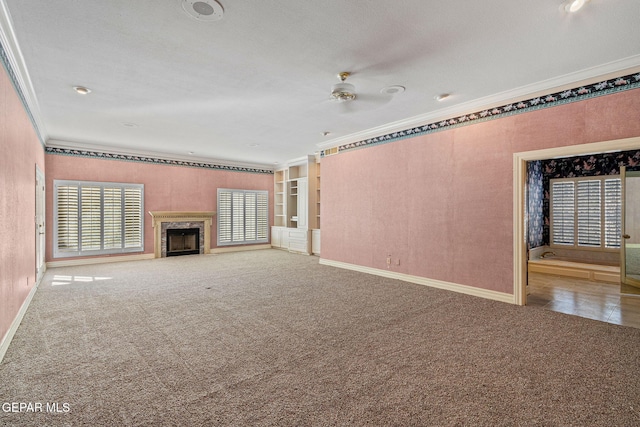 unfurnished living room featuring crown molding, carpet flooring, a fireplace, and baseboards