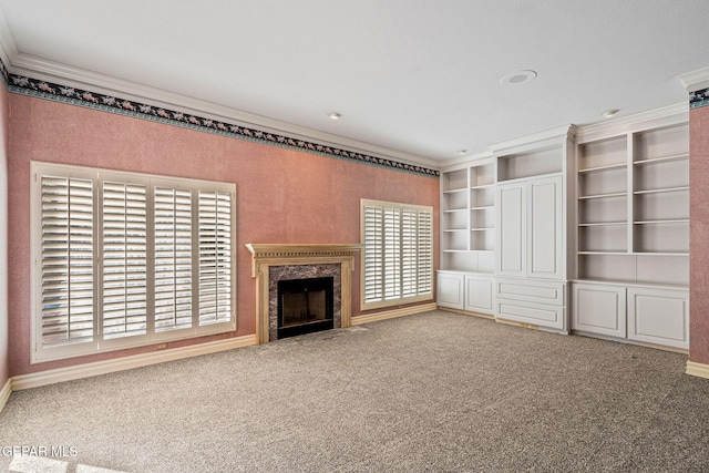 unfurnished living room featuring carpet flooring, plenty of natural light, a fireplace, and crown molding