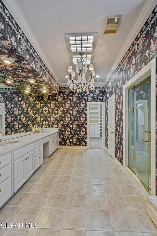 interior space featuring baseboards, wallpapered walls, a stall shower, ornamental molding, and a sink