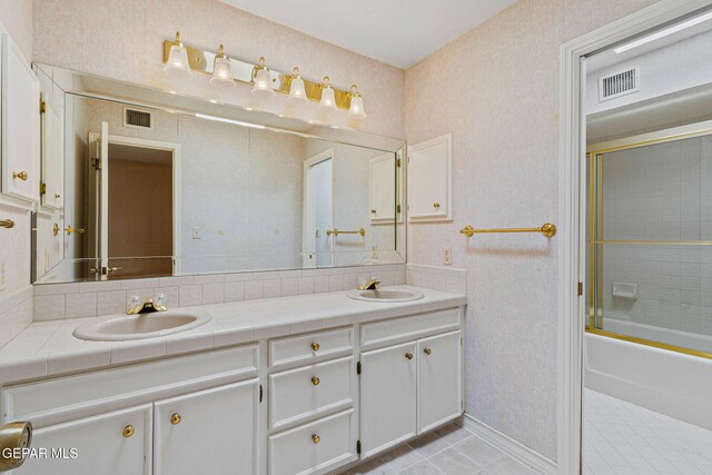 bathroom with a sink, visible vents, and double vanity