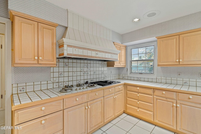 kitchen featuring tile counters, light tile patterned floors, and light brown cabinets