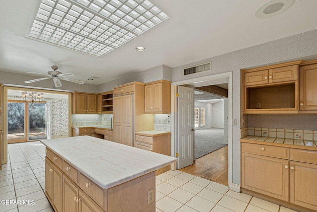 kitchen featuring light tile patterned floors, visible vents, a kitchen island, and open shelves