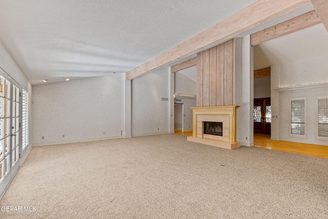 unfurnished living room with plenty of natural light, a fireplace, and carpet floors