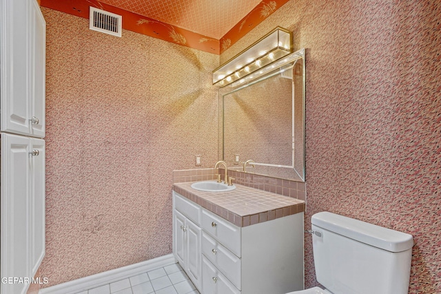 bathroom with visible vents, baseboards, toilet, tile patterned floors, and vanity