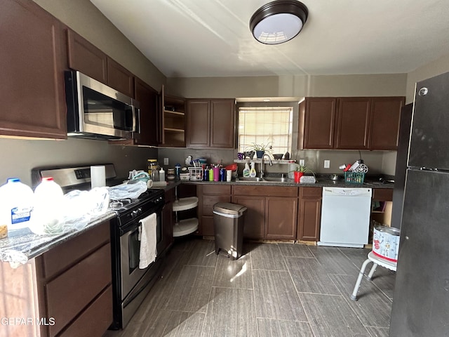 kitchen with open shelves, appliances with stainless steel finishes, and a sink