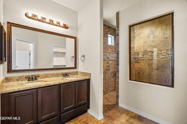 bathroom featuring a tile shower and vanity