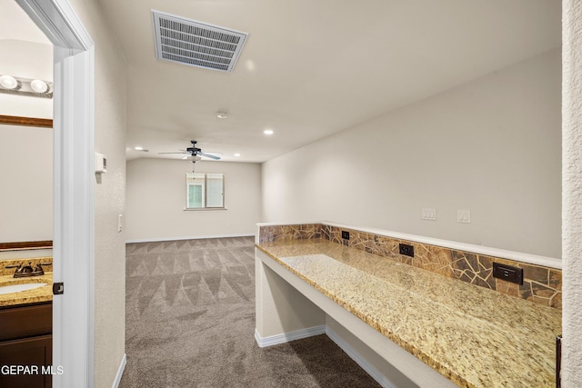 interior space featuring vanity, ceiling fan, and backsplash