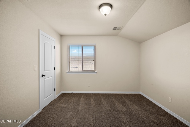 carpeted spare room with vaulted ceiling