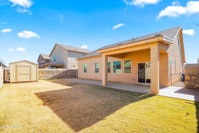 rear view of property featuring a patio area, a yard, and a shed