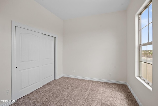 unfurnished bedroom featuring carpet floors and a closet