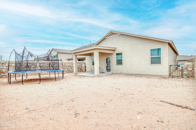 back of house featuring a patio area and a trampoline