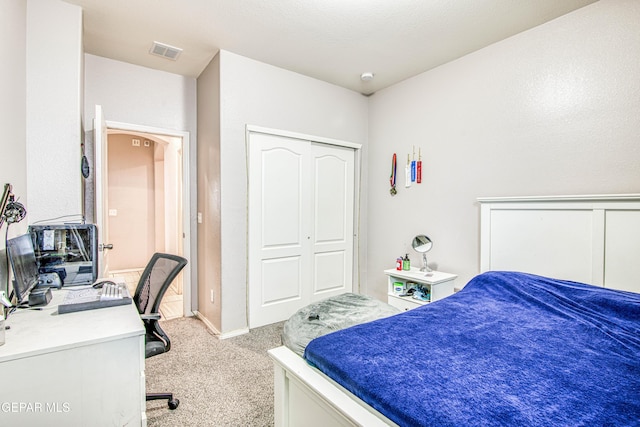 bedroom featuring light colored carpet and a closet