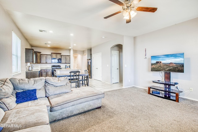 carpeted living room with ceiling fan and sink