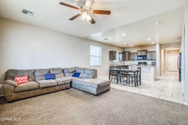 carpeted living room featuring ceiling fan