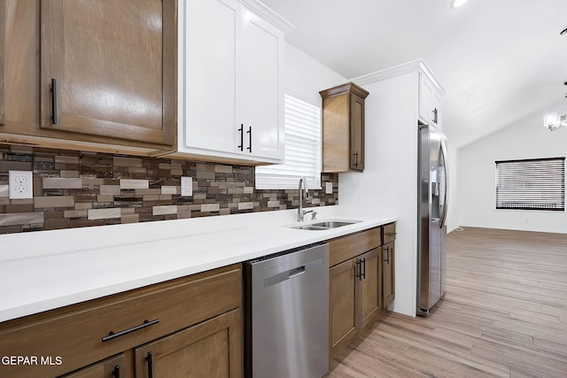 kitchen with white cabinets, sink, decorative backsplash, light hardwood / wood-style floors, and stainless steel appliances