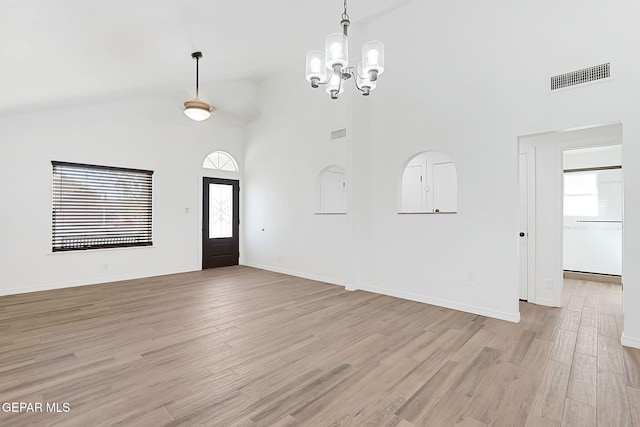 entryway featuring high vaulted ceiling, light hardwood / wood-style flooring, plenty of natural light, and a notable chandelier