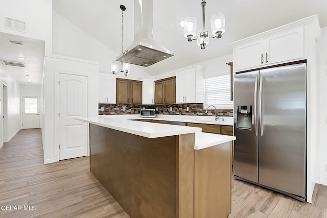 kitchen featuring a center island, plenty of natural light, island range hood, and stainless steel refrigerator with ice dispenser