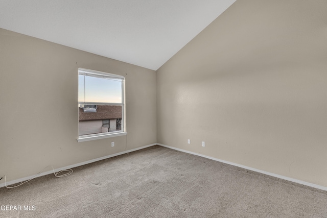 carpeted empty room featuring lofted ceiling