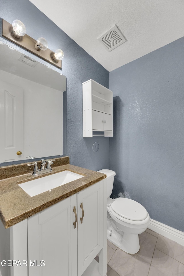 bathroom with tile patterned floors, vanity, and toilet