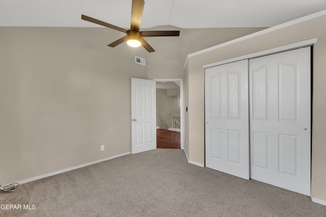 unfurnished bedroom with carpet, a closet, high vaulted ceiling, and ceiling fan