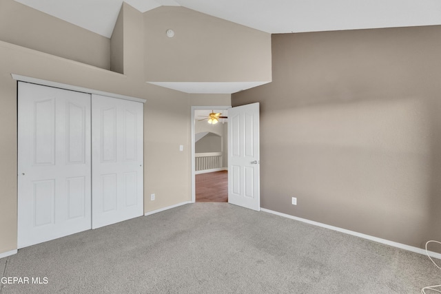 unfurnished bedroom featuring carpet floors, high vaulted ceiling, and a closet